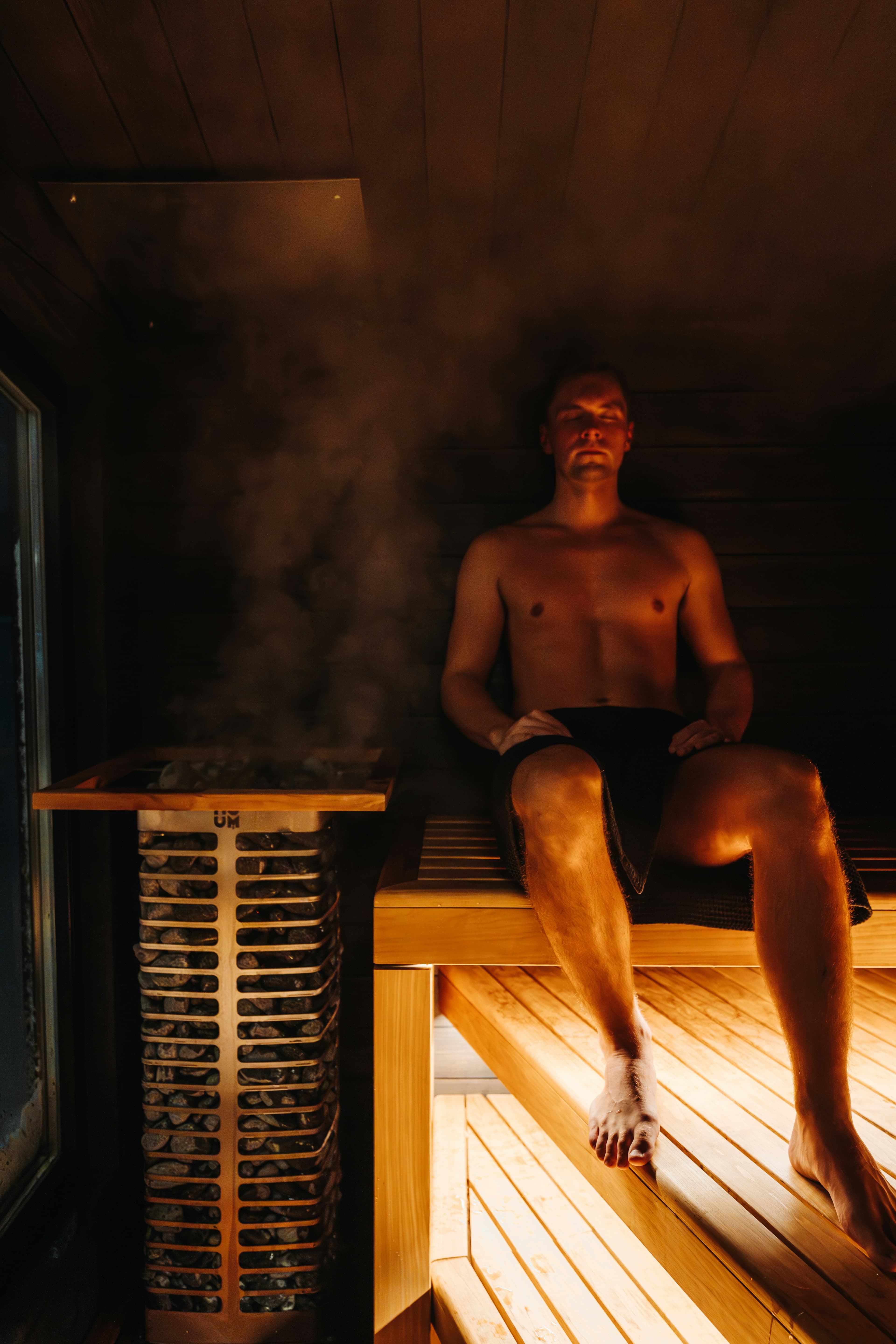 Man relaxing in a warm Finnish sauna for the first time