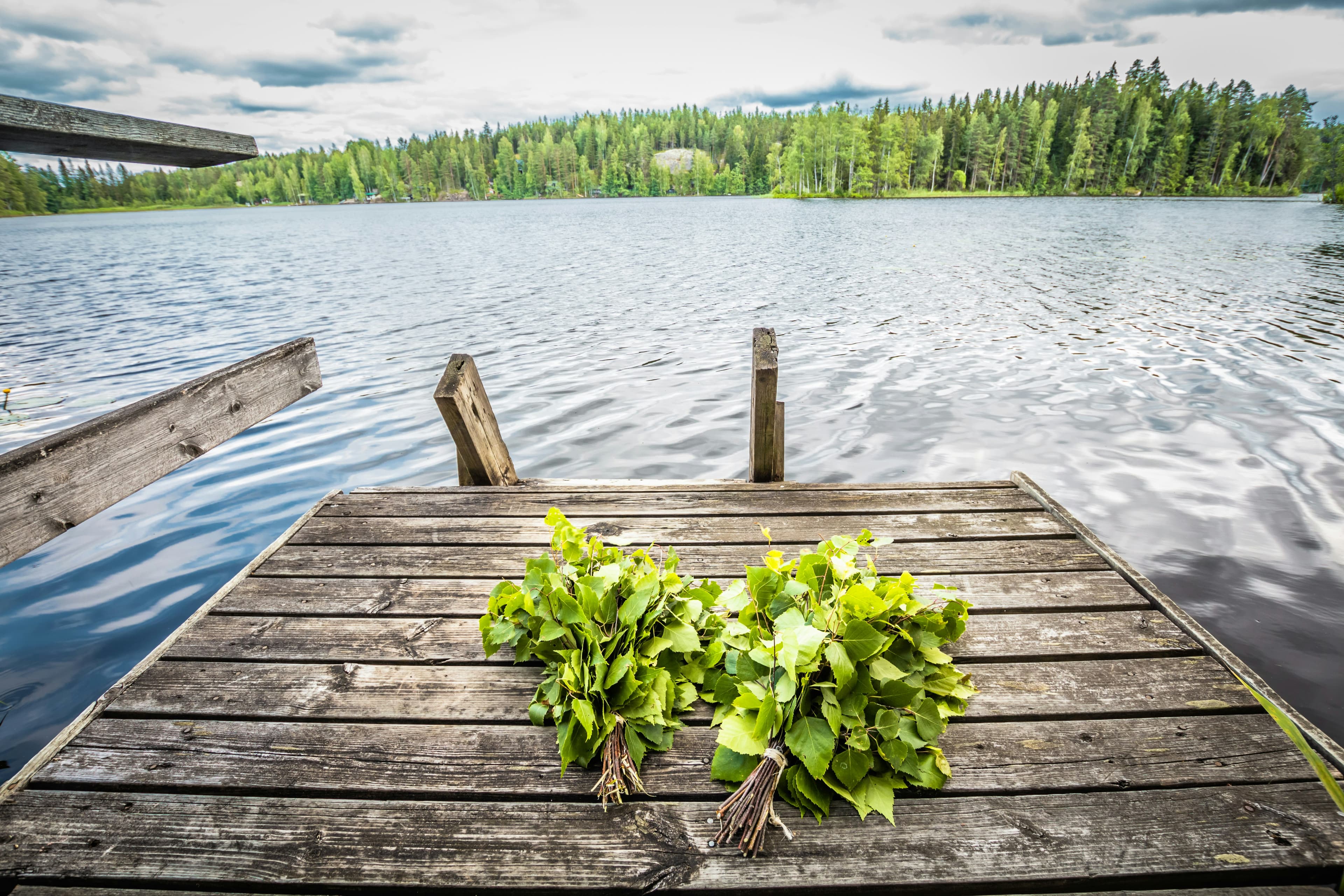 Fresh birch vihta whisks on a Finnish lakeside dock